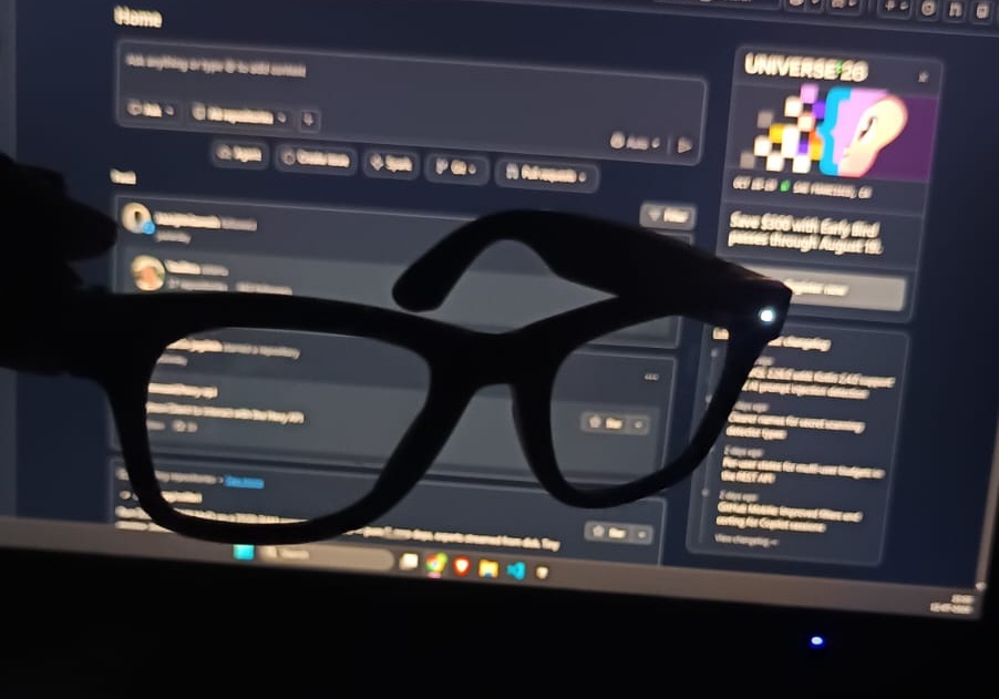 The AI camera glasses held up in front of a monitor